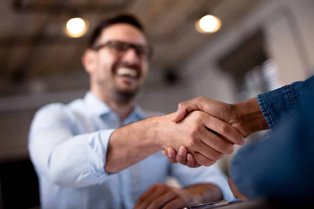 Business person shaking hands with an invoice factoring professional.
